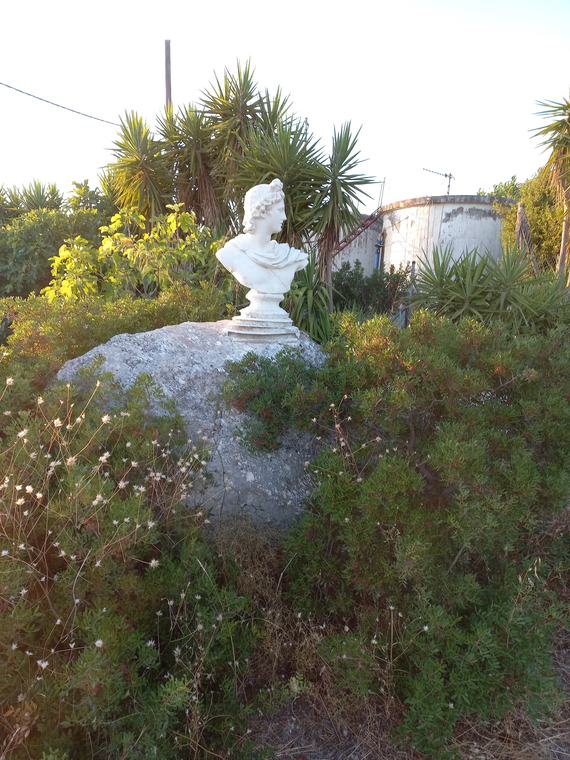 Μεταλλικό ηλιακό ρολόι ανάμεσα στα αρωματικά φυτά